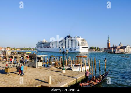 Il liner MSC Poesia salpa sul canale di fronte a Piazza San Marco. Dal 2021 agosto, le grandi navi da crociera non saranno più autorizzate a passare vicino a Piazza San Marco, né al canale della Giudecca in seguito, secondo le autorità, inquinano l'aria e l'acqua, Danneggiare il fondale marino e alterare l'ecosistema della laguna fino ad ora, questo è stato il percorso attraverso il cuore di Venezia preso da tutti i liner che entrano nella laguna per scaricare milioni di turisti all'anno. Dopo diversi mesi di interruzione, i giganti del mare avevano ricominciare a attraversare Venezia all'inizio di giugno. (Foto di Den Foto Stock