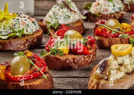 Tartine su fette di baguette tostate con vari condimenti Foto Stock