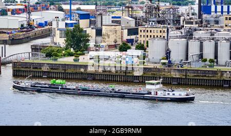 Amburgo, Germania, 22 luglio 2021: La petroliera piatta per il trasporto di canali interni naviga di fronte alla banchina del porto petrolifero sul fiume Elba Foto Stock