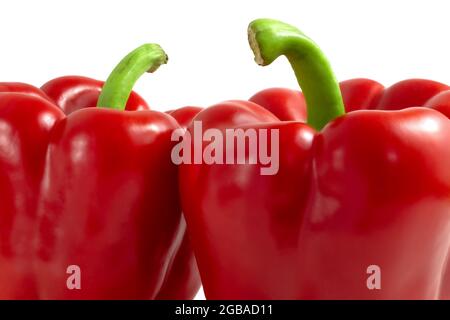 Due peperoni rossi con steli verdi da vicino Foto Stock