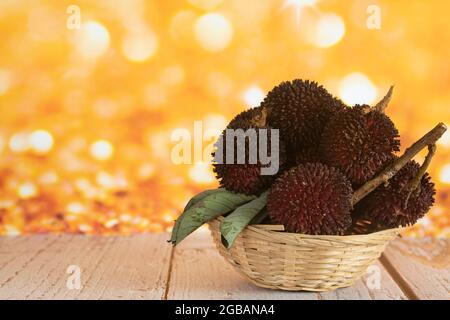 Un cestino pieno di pulasan, un frutto tropicale della famiglia dei frutti di bosco, simile al rambutan. Messa a fuoco selettiva. Sfondo sfocato Foto Stock