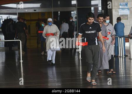 Lahore, Pakistan. 3 agosto 2021. Ventotto pakistani liberati dalla prigione dell'Arabia Saudita hanno raggiunto l'aeroporto Allama Iqbal di Lahore. Il governo ha pagato il viaggio di 19 passeggeri. Sono arrivati all'aeroporto di Allama Iqbal tramite il volo PIA 9248 il martedì mattina. Saranno condotti i test del Covid-19 e sarà loro permesso di lasciarli una volta chiari. Farrukh Habib di PTI e Ijaz Chaudhry li accolsero. Essi hanno detto che prima di questo, 62 pakistani sono stati riportati. (Foto di Rana Sajid Hussain/Pacific Press/Sipa USA) Credit: Sipa USA/Alamy Live News Foto Stock