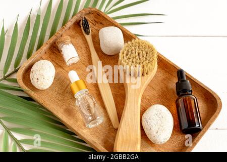 Prodotti cosmetici naturali per la cura della pelle e spa con prodotti essenziali ecologici in vassoio di legno su sfondo bianco. Foto Stock