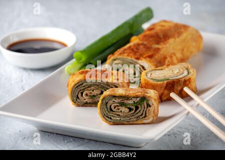 Cucina giapponese. Tamagoyaki - frittata giapponese, arrotolato diversi strati di uova fritte Foto Stock