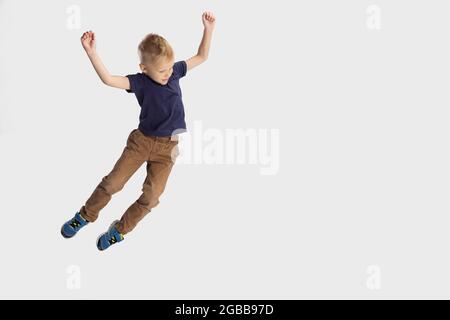 Ritratto del ragazzo di scuola, allievo cadente isolato su sfondo bianco studio. CopySpace per l'annuncio. Infanzia, educazione, concetto di emozione. Foto Stock