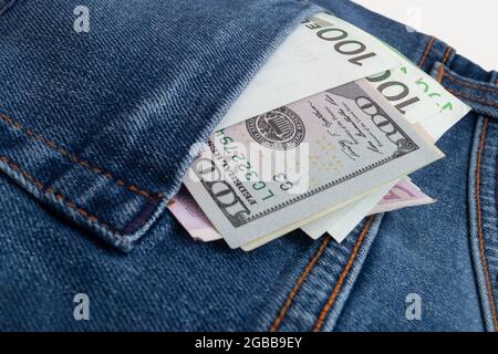 dollari ed euro che si attaccano dalla tasca dei jeans Foto Stock