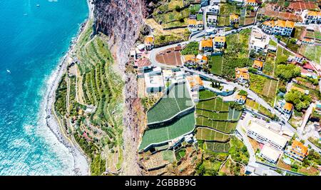 Campi verdi terrazzati dall'alto dell'oceano turchese, Camara de Lobos, isola di Madeira, Portogallo, Atlantico, Europa Foto Stock