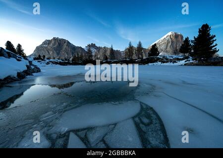 Crepuscolo si illumina sul lago ghiacciato Limides con Lagazuoi e Tofana di Rozes sullo sfondo, Dolomiti, Veneto, Italia, Europa Foto Stock