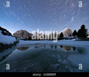 Sentiero polare nel cielo notturno sulle cime di Lagazuoi e Tofana di Rozes dal lago ghiacciato Limides, Dolomiti, Veneto, Italia, Europa Foto Stock