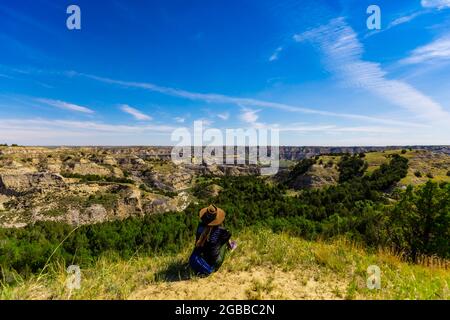 Donna che gode la vista lungo il Theodore Roosevelt National Park North Unit, North Dakota, Stati Uniti d'America, Nord America Foto Stock