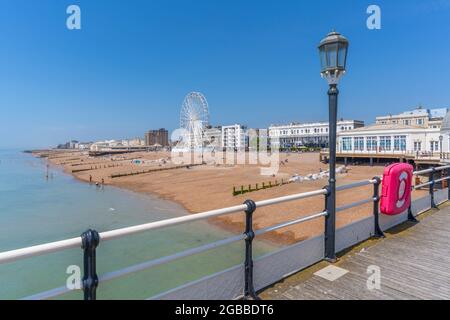 Vista delle case fronte spiaggia e ruota panoramica dal molo, Worthing, West Sussex, Inghilterra, Regno Unito, Europa Foto Stock