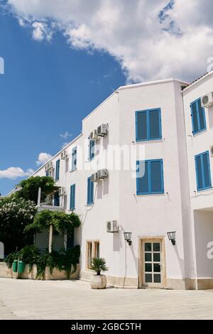 Edificio di appartamenti bianco a tre piani con vegetazione intorno Foto Stock