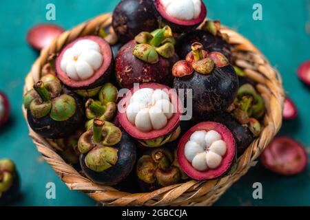 Mangosteen frutta su sfondo di legno azzurro chiaro, frutta tropicale Foto Stock