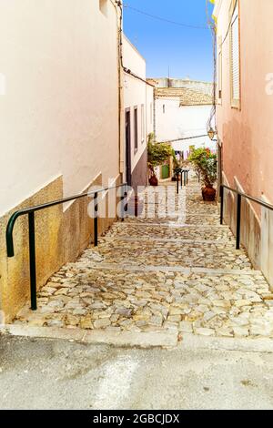 Tipico Algarve ripida strada laterale percorso a piedi lastricato con tradizionali ciottoli portoghesi o calcada. Estoi Algarve Portogallo Foto Stock