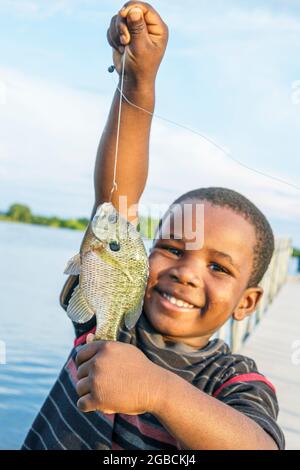 Alabama Lake Eufaula Lakepoint Resort state Park, Chattahoochee River, Black boy pesca mostrando pesce catturato sorridendo orgoglioso, Foto Stock