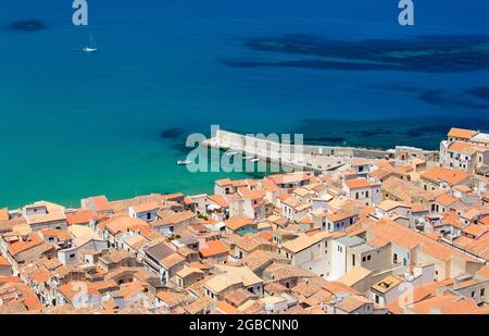 Cefalù, Palermo, Sicilia, Italia. Vista sui tetti piastrellati della Città Vecchia da la Rocca, le acque turchesi del Mar Tirreno oltre. Foto Stock