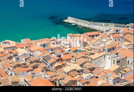 Cefalù, Palermo, Sicilia, Italia. Vista sui tetti piastrellati della Città Vecchia da la Rocca, le acque turchesi del Mar Tirreno oltre. Foto Stock