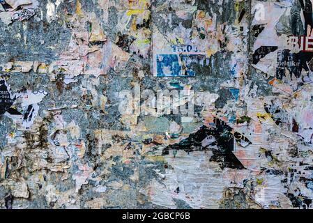 Collage di poster scraps incollato su un muro come sfondo a Cracovia, Polonia Foto Stock