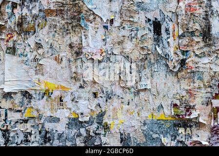 Collage di poster scraps incollato su un muro come sfondo a Cracovia, Polonia Foto Stock