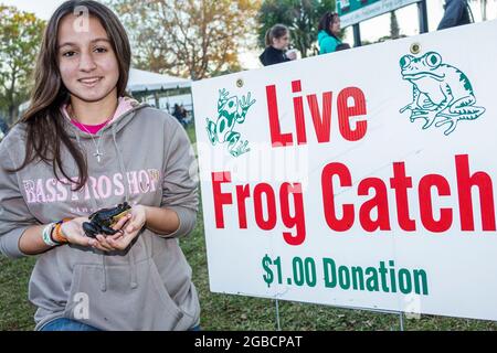 Florida Fellsmere, Fog leg Festival annuale dal vivo rana cattura gioco donazione, teen teenager adolage ragazza volontario holding, Foto Stock