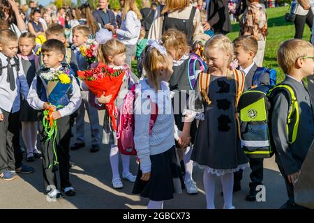 I primi classificati festeggiano l'inizio dell'anno scolastico il 1 settembre. I bambini vanno al primo grado con i fiori. Concetto di istruzione scolastica. Mosca, Russ Foto Stock