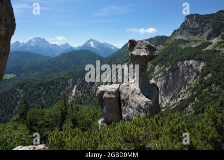 Formazione rocciosa bizzarra Steinerne Agnes e le montagne di Blaueisspitze, Hochkalter e Watzmann sullo sfondo, Bischofswiesen, Baviera, Germania Foto Stock