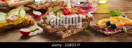 Toast vegetariani appetitosi assortiti con frutta e verdura messi a tavola per uno spuntino sano Foto Stock