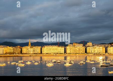 Gli edifici lungo Playa de la Concha a San Sebastian, Spagna, illuminati dagli ultimi raggi del sole serale Foto Stock