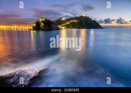 La baia di San Sebastian in Spagna con Monte Igueldo dopo il tramonto Foto Stock