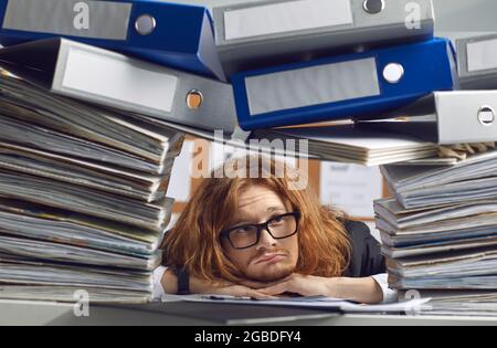 Triste lavoratore d'ufficio che è sopraffatta con i sogni di lavoro di un fine settimana o di una vacanza. Foto Stock