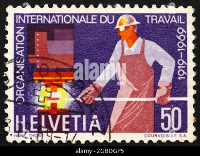 SVIZZERA - CIRCA 1969: Un francobollo stampato in Svizzera mostra Steelworker, 50° anniversario dell'Organizzazione Internazionale del lavoro, circa 1969 Foto Stock