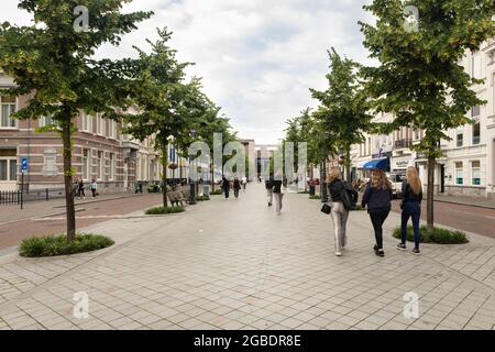 Breda, Paesi Bassi 28 giugno 2021. Persone che camminano sul grande viale vicino alla stazione con monumentali edifici storici sul lato e gli alberi o Foto Stock