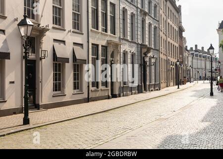 Breda, Paesi Bassi 28 giugno 2021. Strada nel centro della città con vecchi edifici storici con facciate chiare, un marciapiede e lanterne su un soleggiato Foto Stock