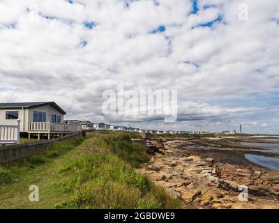 Vista del Church Point Holiday Park a Newbiggin dal mare a bassa marea con centrale elettrica e spazio per fotocopie. Foto Stock