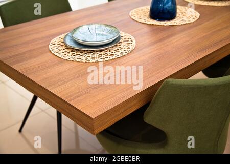 Moderna cucina interna, tavolo da pranzo in legno noce e sedie verdi Foto Stock