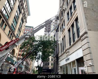New York, NY, Stati Uniti d'America - 3 agosto 2021: Scale di estensione dal camion del fuoco di NYC usate per accedere al piano alto a 2 W 16th St a Manhattan Foto Stock