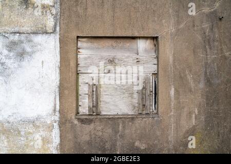 Finestra a bordo nel muro dell'edificio esterno Foto Stock