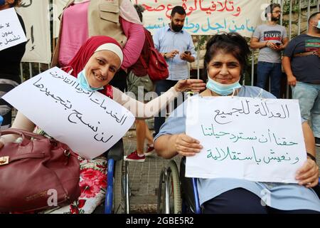 Beirut, Libano. 3 agosto 2021. Due donne permanentemente ferite da Port Blast del 4 agosto 2020 protestano al Palazzo di Giustizia di Beirut, Libano, il 3 agosto 2021. Alla vigilia del primo anniversario dell'esplosione, le persone ferite e le famiglie dei defunti attendono ancora il Parlamento per revocare l'immunità dal perseguimento di tutti i politici e funzionari coinvolti nell'incidente.(Elisa Gestri/Sipa USA) Credit: Sipa USA/Alamy Live News Foto Stock