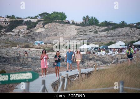 FORMENTERA, SPAGNA - 19 luglio 2021: La gente che cammina sul sentiero nella spiaggia di es Pujols a Formentera, Isole Baleari, Spagna Foto Stock