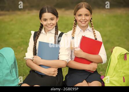 bambine con libri e zaini. i bambini tengono un notebook per prendere appunti. infanzia felice. ritorno a scuola. ragazzi pronti per la lezione. preparatevi Foto Stock