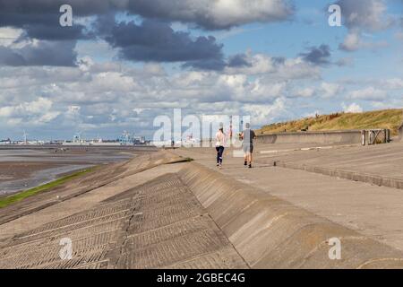 Wallasey Embankment, Wirral, Regno Unito. Corridori sul sentiero lungo il North Wirral Coastal Park. Foto Stock