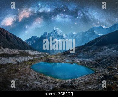 Milky Way su montagne innevate e lago di notte. Orizzontale Foto Stock