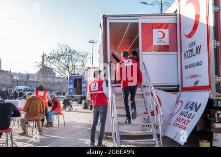 Eminonu, Istanbul, Turchia - 02.26.2021: Volontari e lavoratori della donazione di sangue. Traduzione sul tavolo dell'auto: Turco Red Crescent Blood Donation Veh Foto Stock