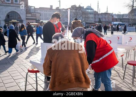 Eminonu, Istanbul, Turchia - 02.26.2021: Un colpo medio di dipendente femminile della Mezzaluna Rossa turca aiuta la donazione di sangue volontario Foto Stock