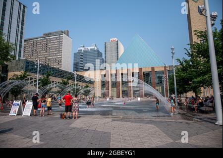 Edmonton, Alberta - 30 luglio 2021: Persone che giocano nelle fontane di fronte al municipio di Edmonton. Foto Stock