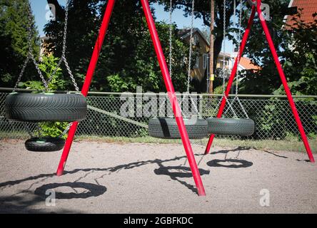 Altalena fatta con pneumatici per auto nel parco giochi Foto Stock