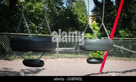 Altalena fatta con pneumatici per auto nel parco giochi Foto Stock