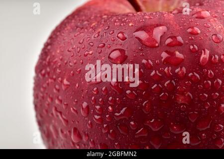 mela rossa fresca con acqua goccia macro in fuoco selettivo, consistenza della frutta Foto Stock