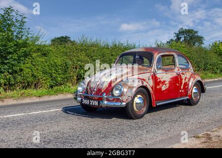 1959, 50s anni cinquanta Rusty left drive rosso vecchio tipo VW Volkswagen Beetle, Käfer, Vocho, Fusca, Cocinelle, Maggiolino, Punch Buggy, People’s Car, raffreddato ad aria, con motore posteriore, Auto compatta a trazione posteriore 1200cc 2DR sulla strada per Capesthorne Hall Classic Car Show di luglio, Cheshire, Regno Unito Foto Stock