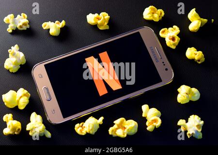 DELHI, INDIA - 14 dicembre 2018: Logo Netflix su smartphone con popcorn su sfondo nero Foto Stock